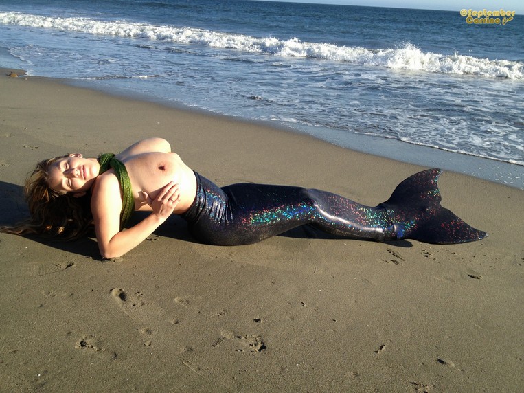 September Carinno as a busty mermaid at the beach.